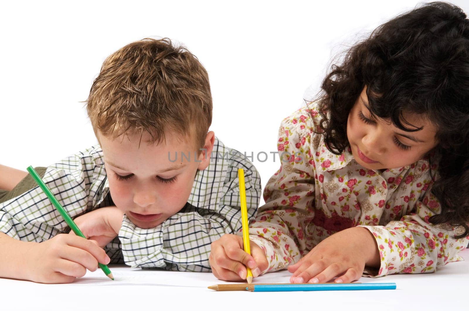 Two friends are drawing together, lying on the floor.