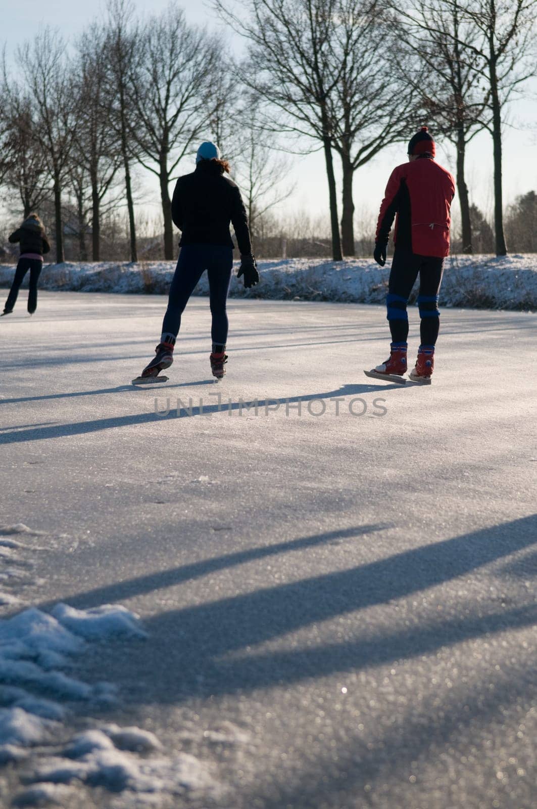 Skaters on a frozen river during a lovely winter day