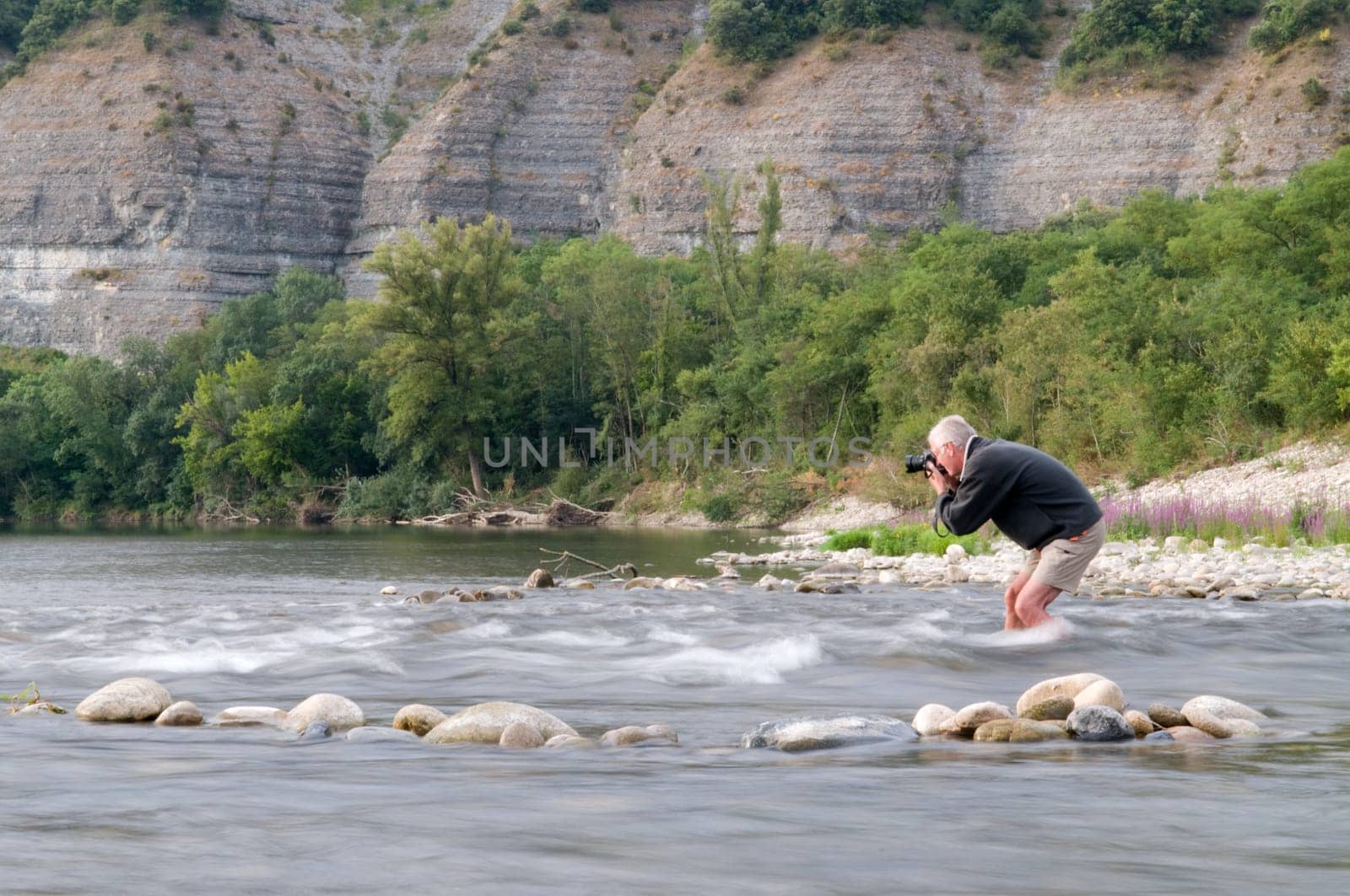 Photographer risking his camera in the stream of the Ardeche, France