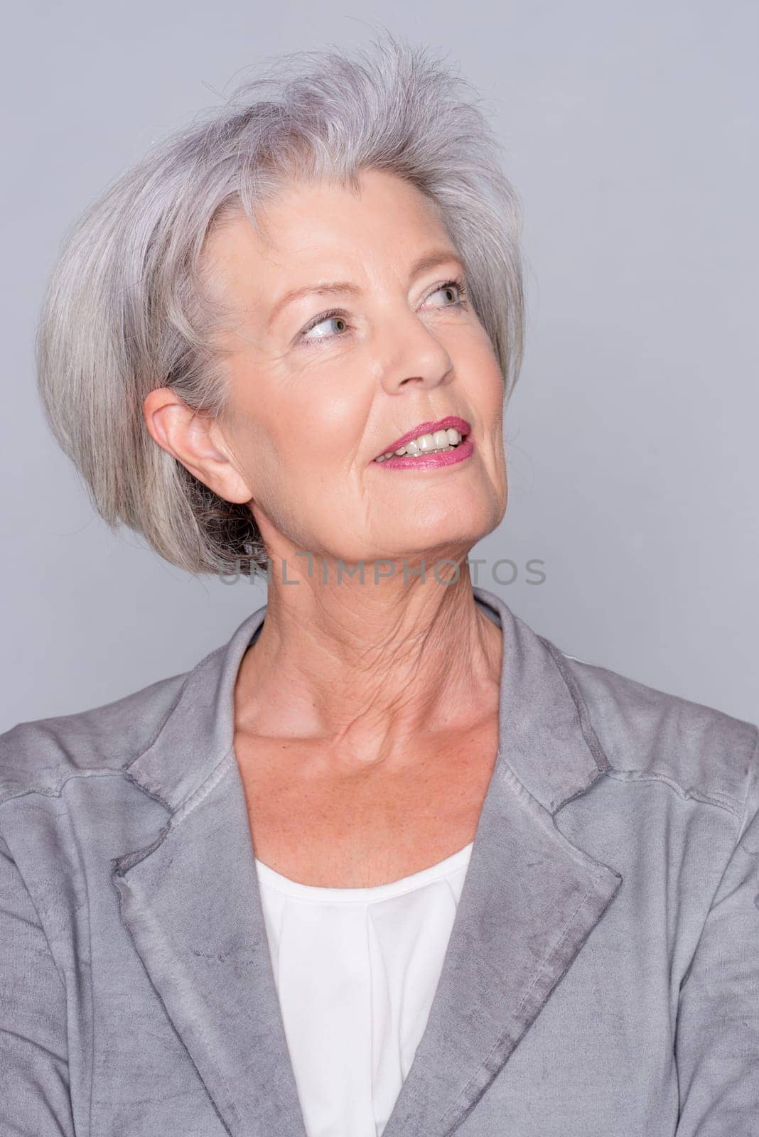 Studio recording of an active senior woman against a grey background