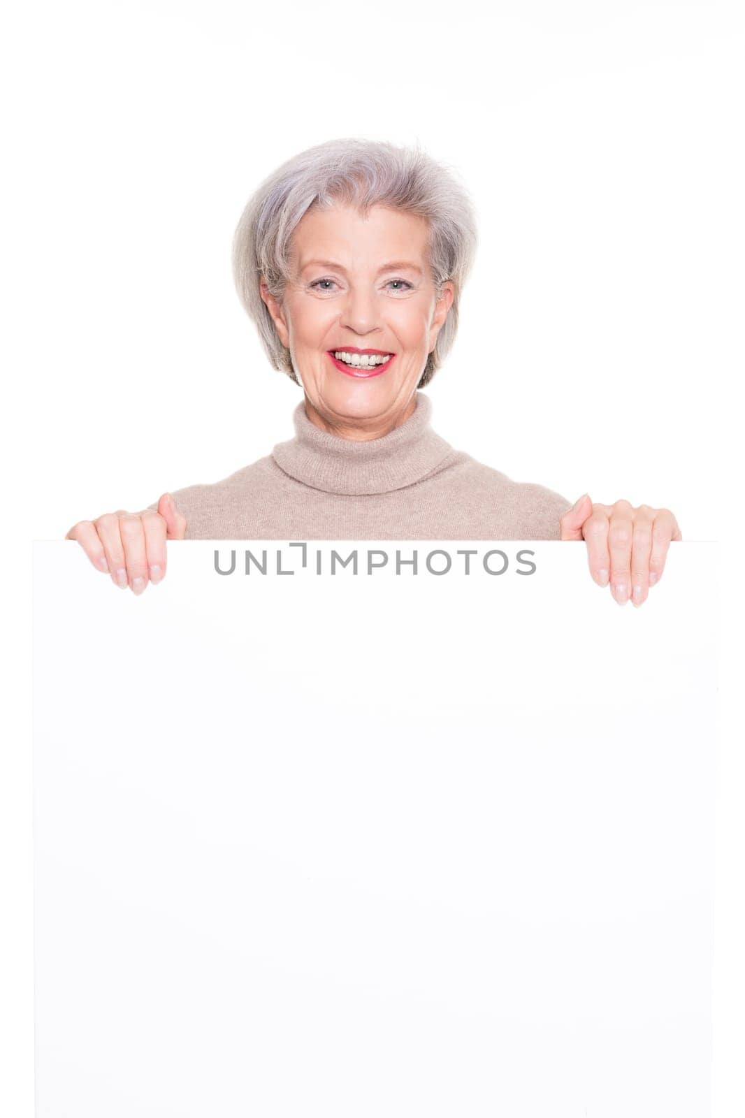Smiling senior woman with an empty advertising sign against a white background
