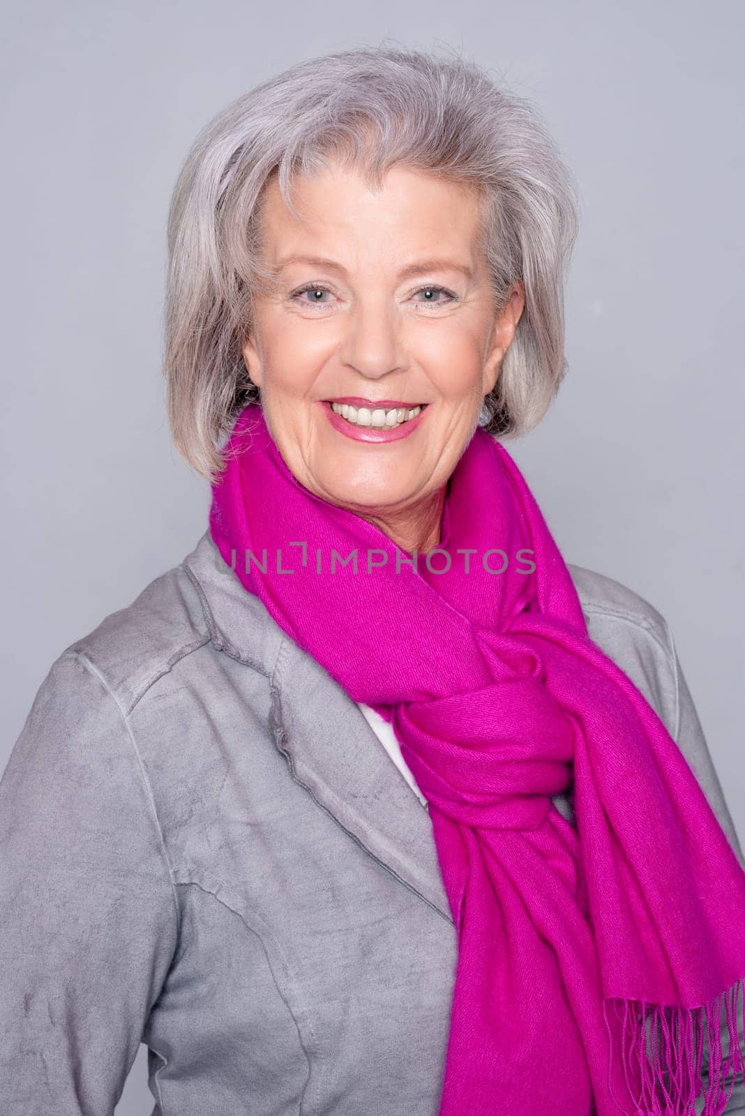 Studio recording of an active senior woman against a grey background