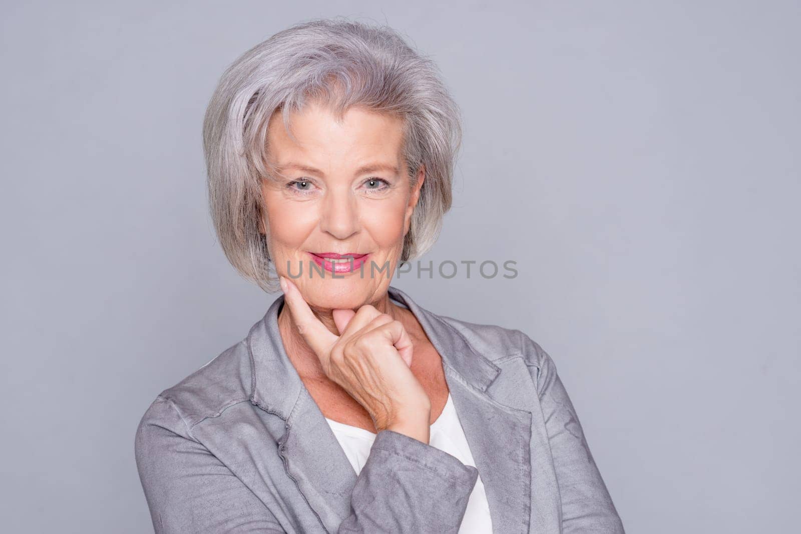 studio shot of an active senior citizen in front of gray background