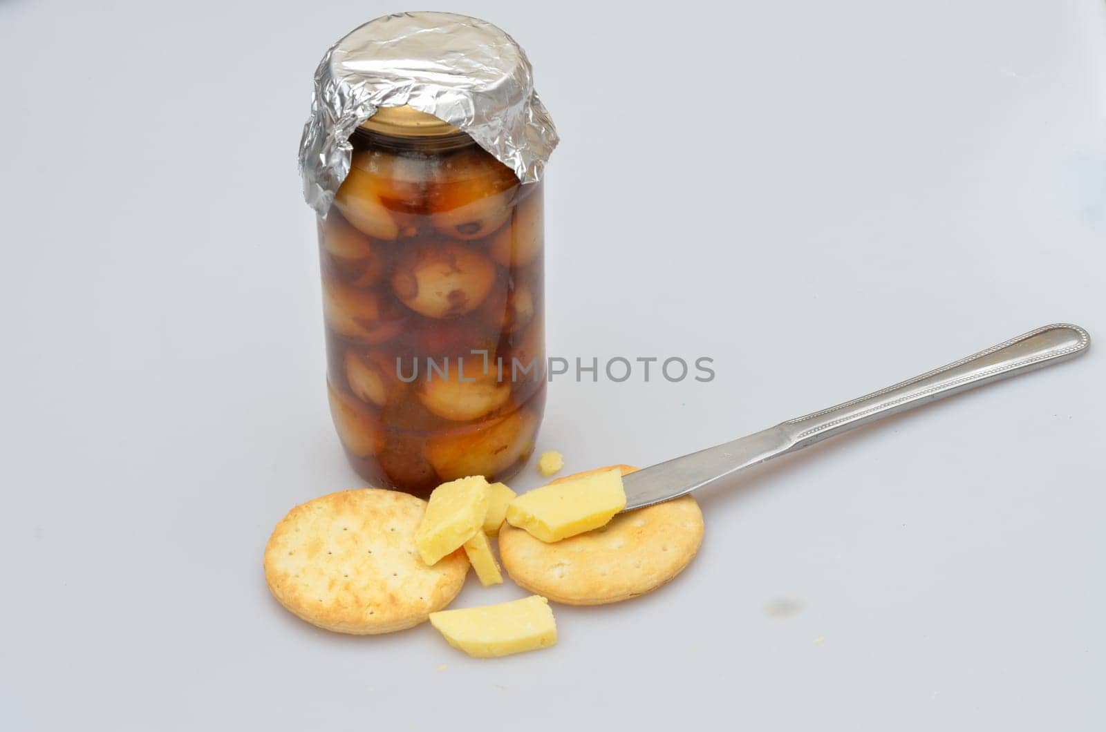 jar of home made pickled onions cheese and biscuits and knife