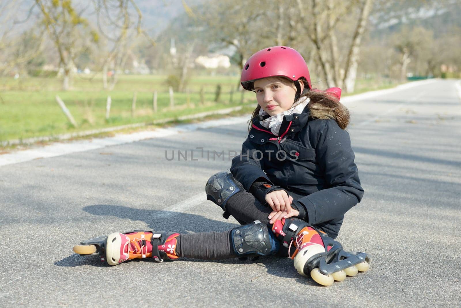 young attractive teenage skater grimacing in pain after taking a fall on the asphalt