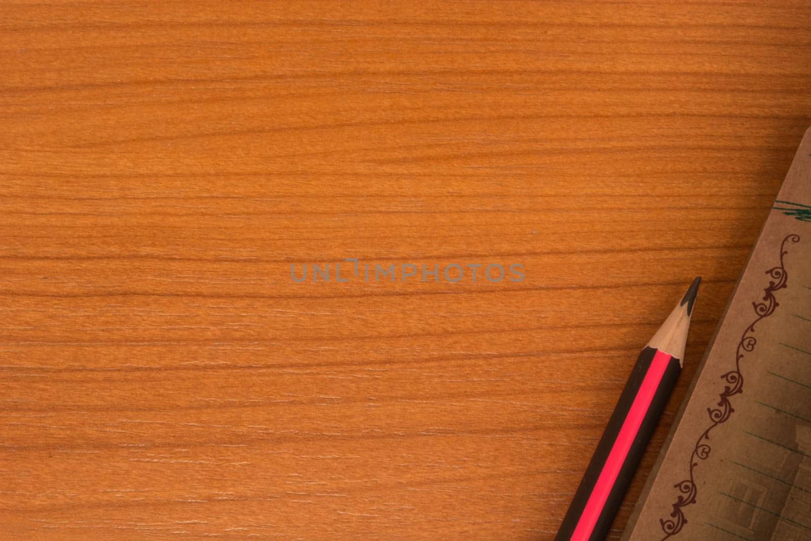 Wooden table with notebook and pencil in one corner