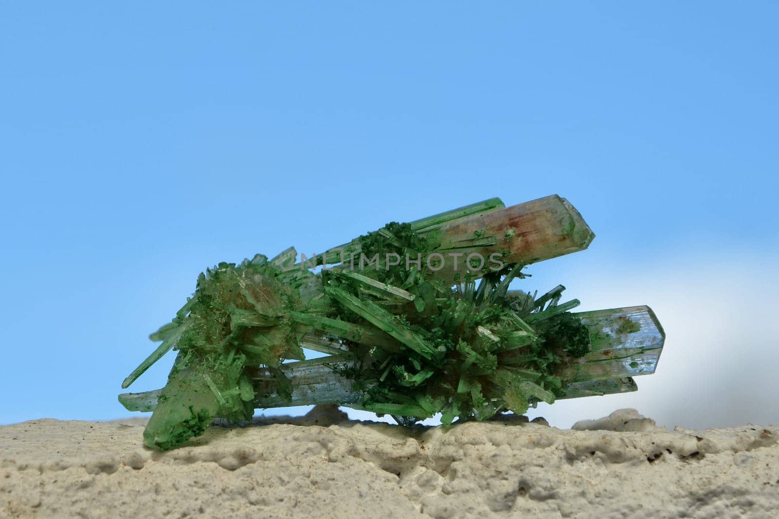 By storing copper oxides green colored gypsum - crystal calcium sulfate dihydrate on white wall in sunlight