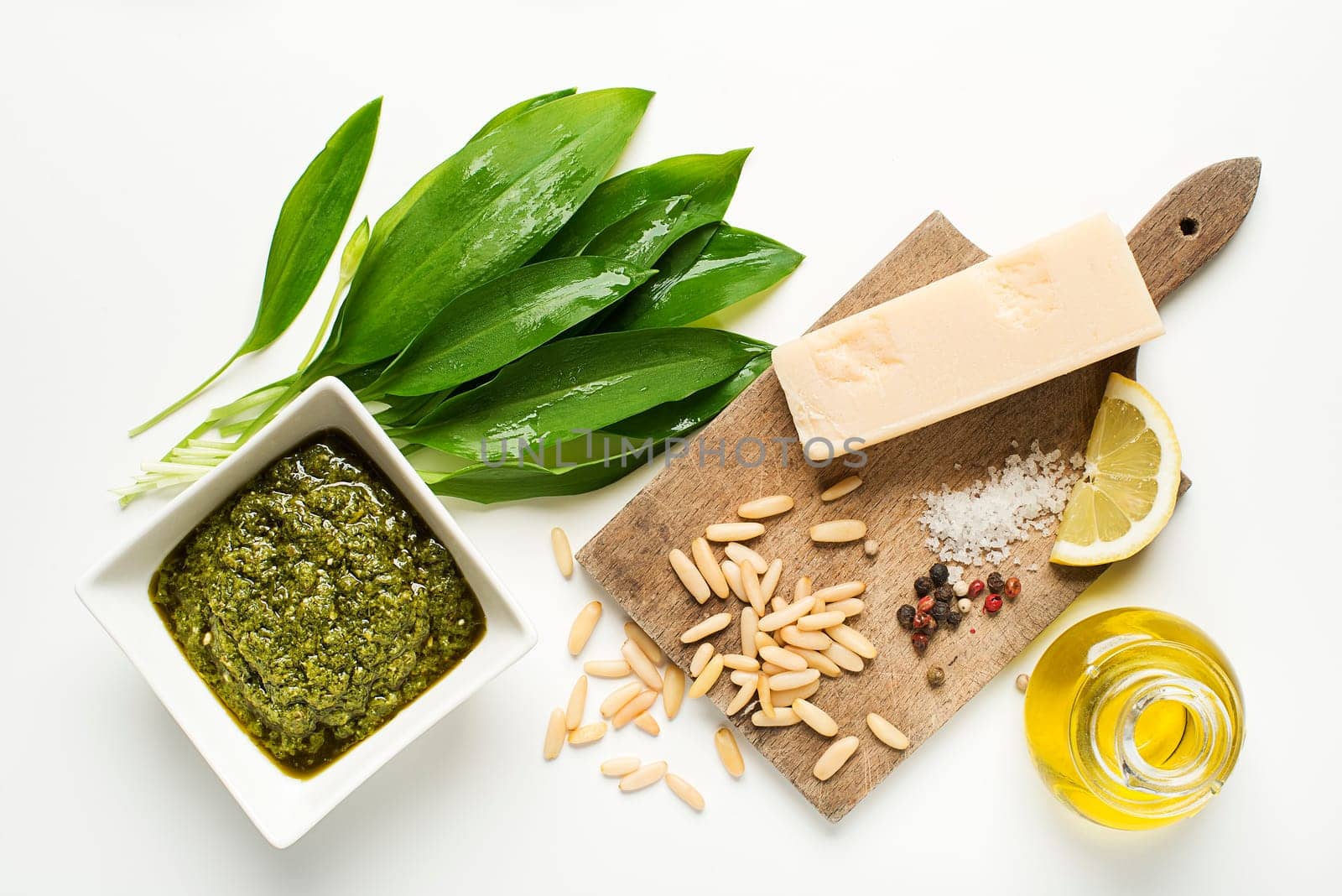 Wild garlic pesto ingredients on white background overhead shoot