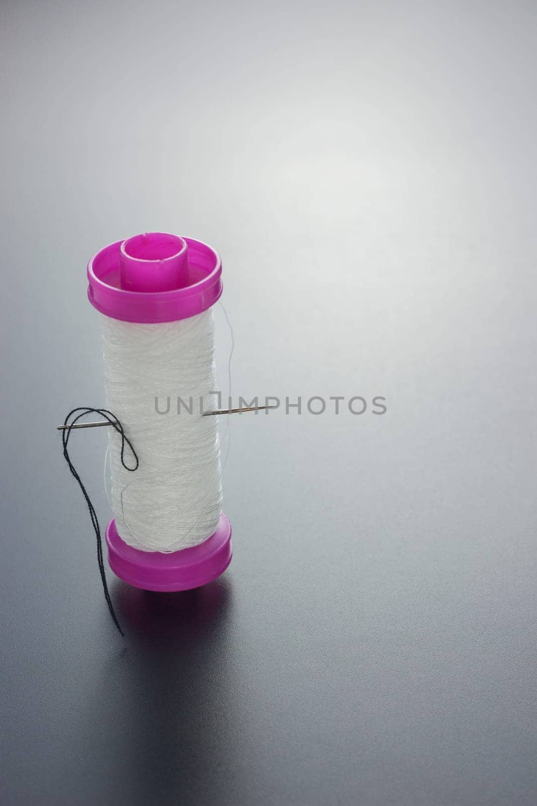 White bobbin with needle isolated on white