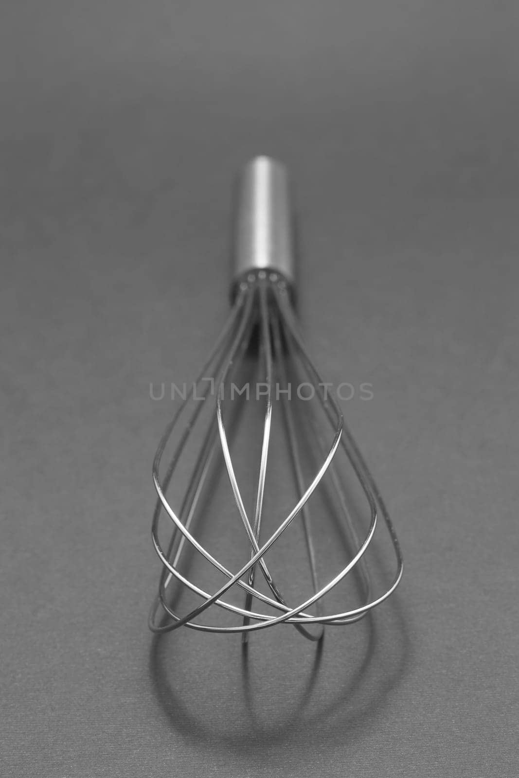 Manual hand egg beater mixer isolated on gray background