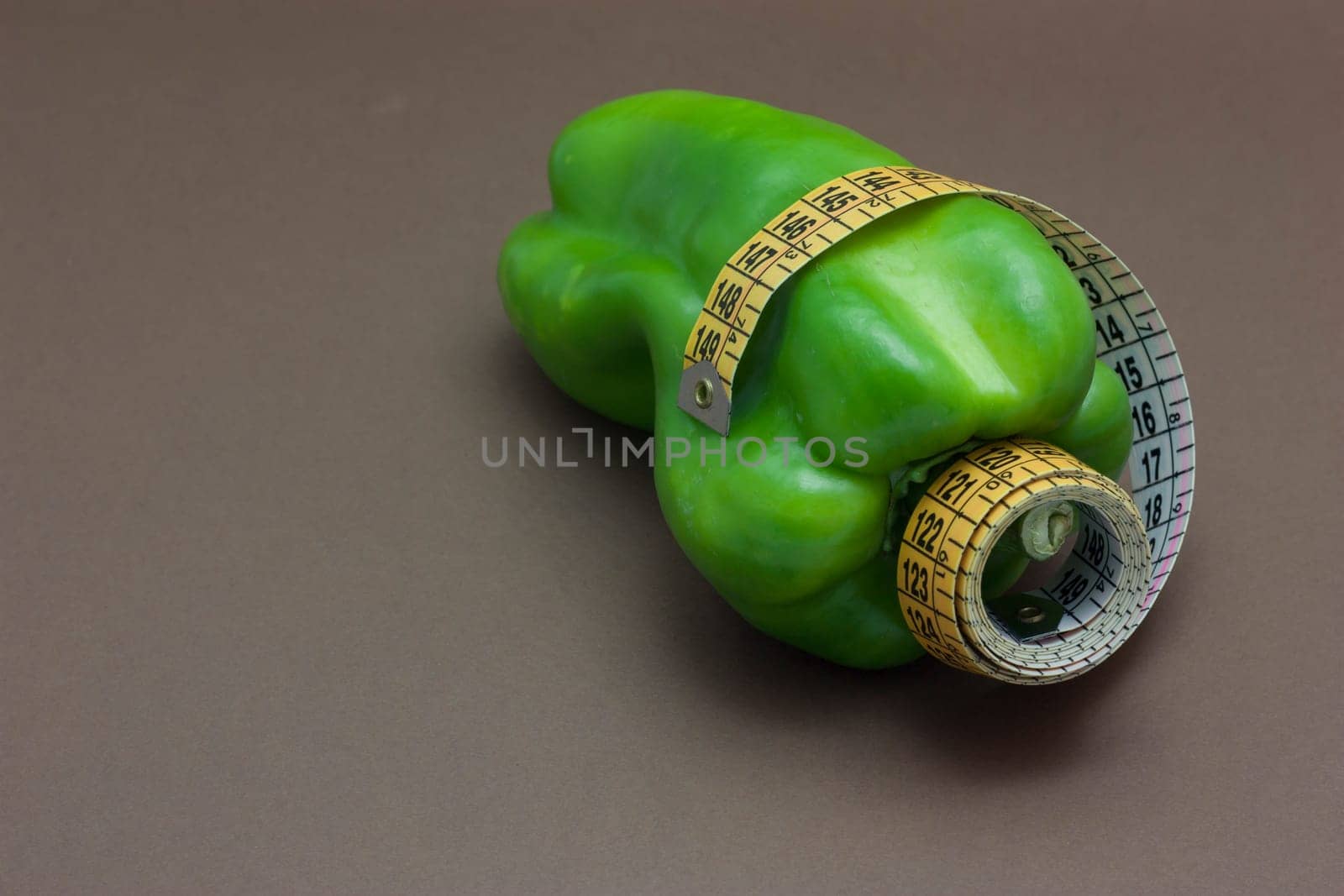 Green pepper isolated on a brown background to understand a concept to healthy eating