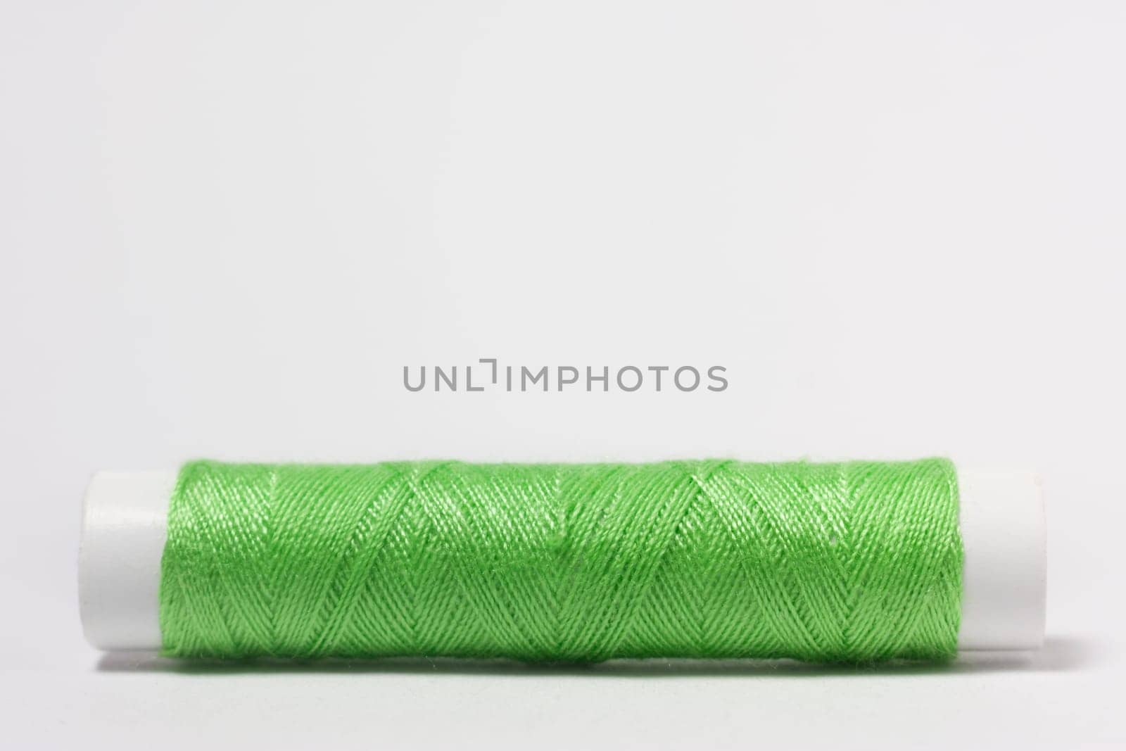 Green cotton thread on a white background