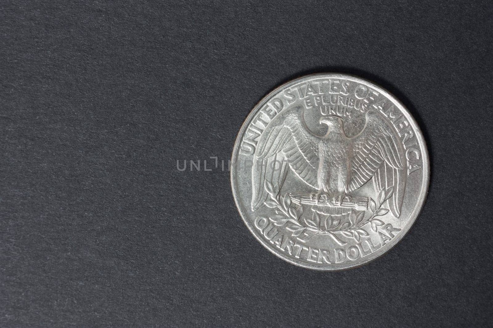 A quarter of the US dollar on the black background