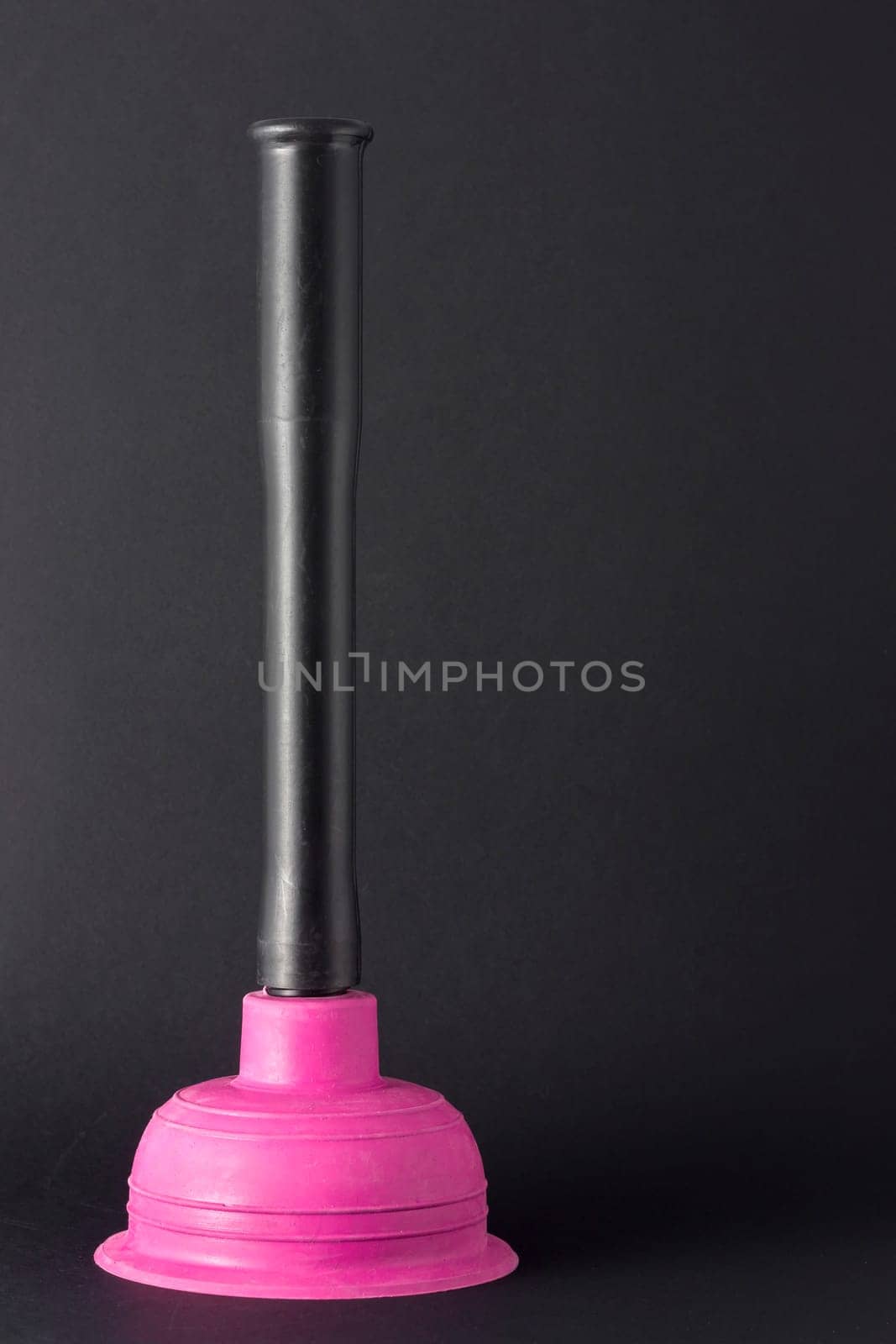Rubber plunger with plastic handles on a dark background