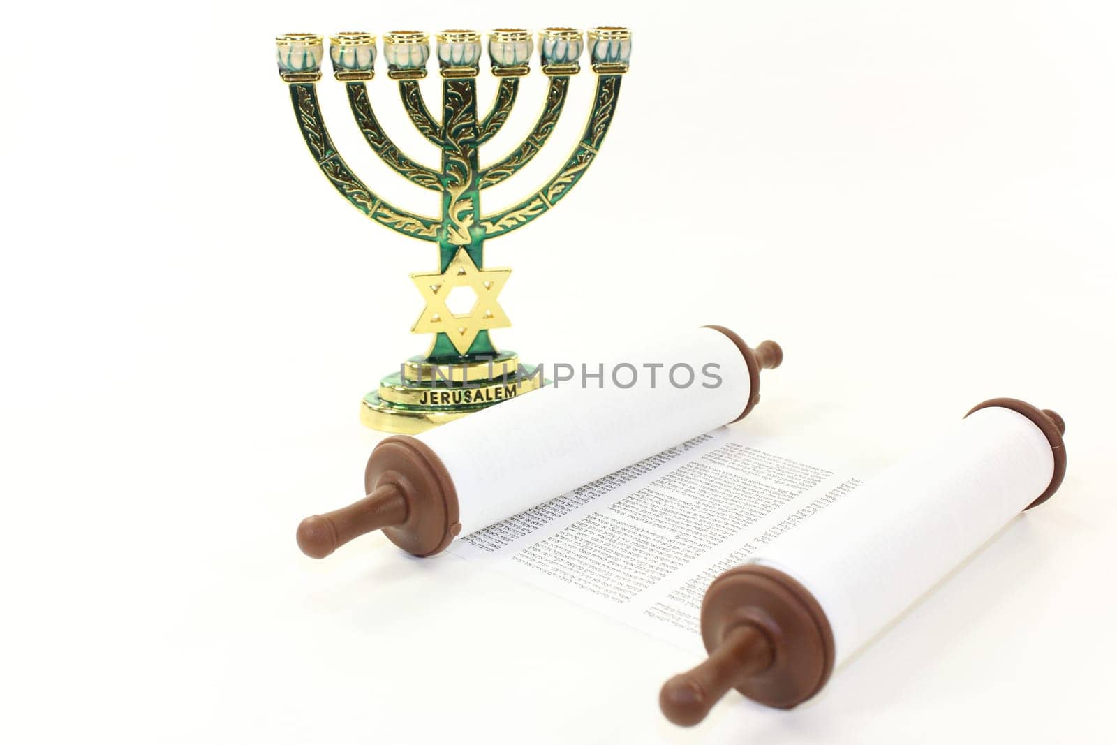 Jewish candlestick and Torah scroll against a white background