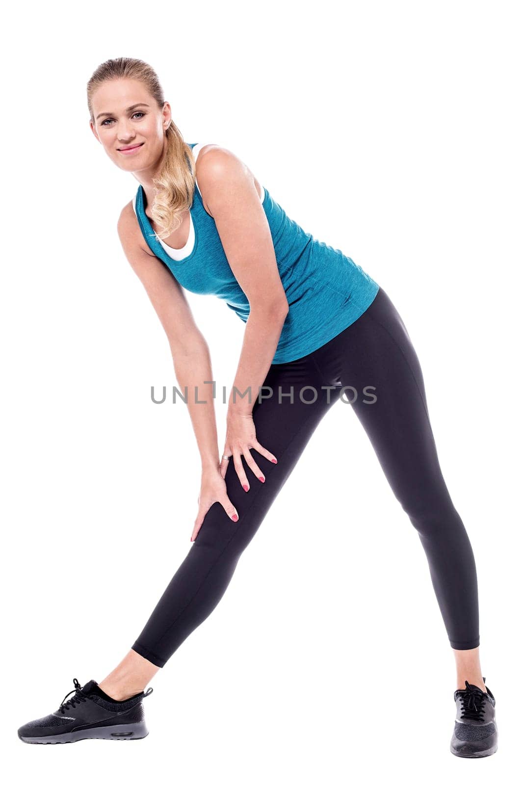 Young fitness woman bending down, exercising.