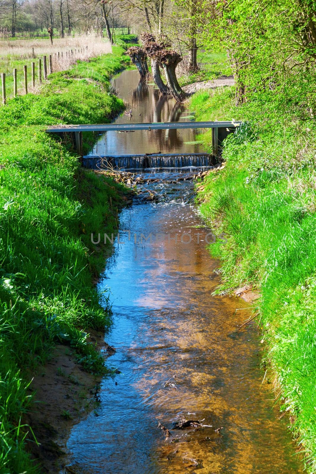 picturesque brook landscape between agricultural fields in The Netherlands