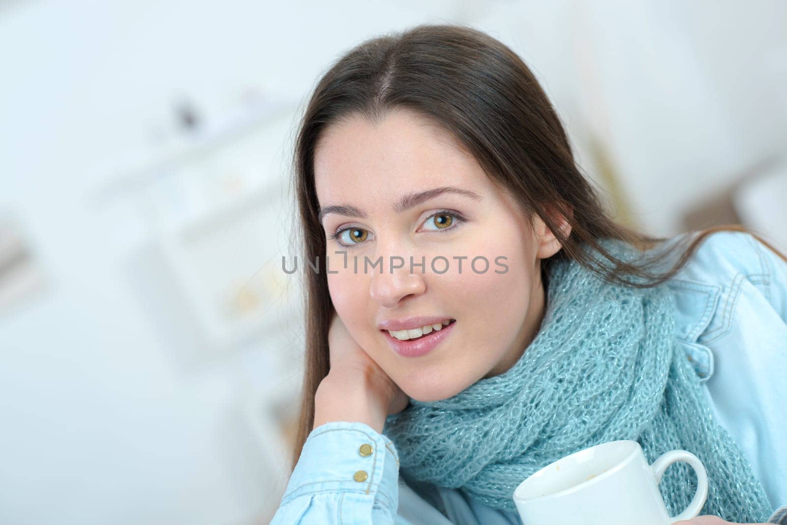 Woman drinking a cup of coffee on the sofa