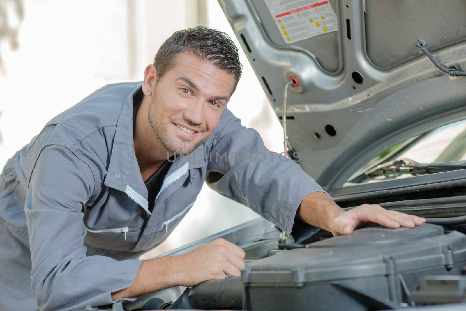 Mechanic stood by a car