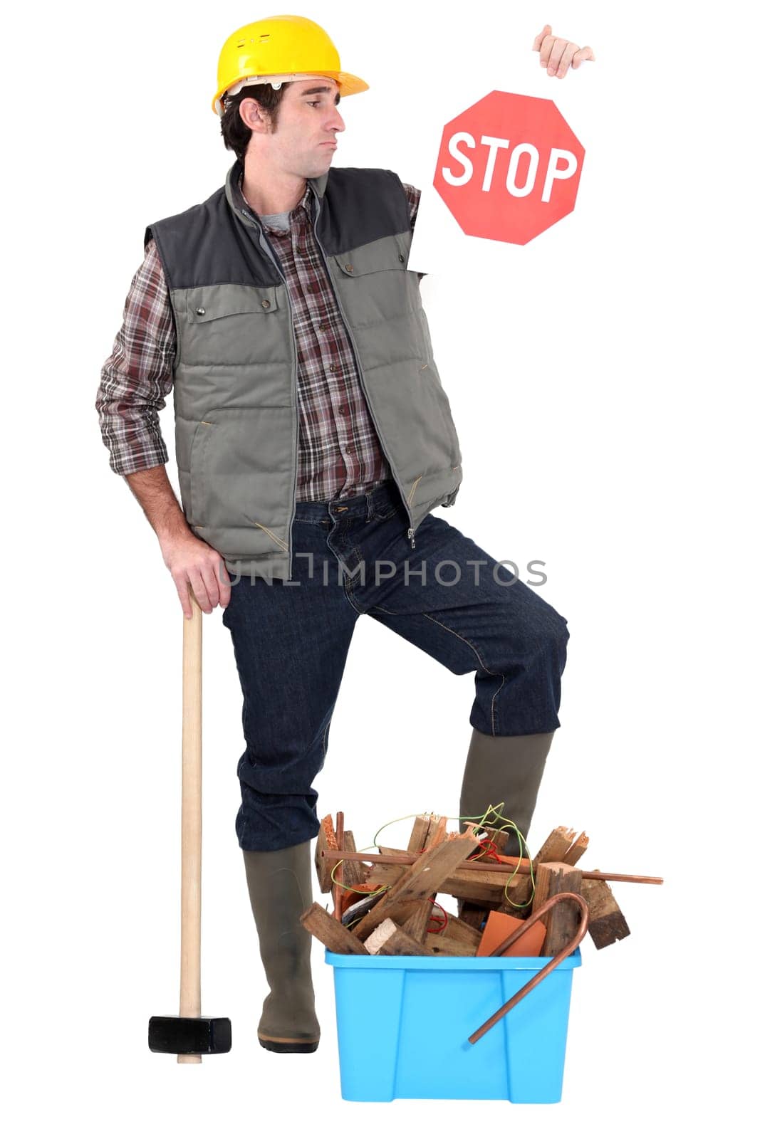 Worker with a stop sign over old materials