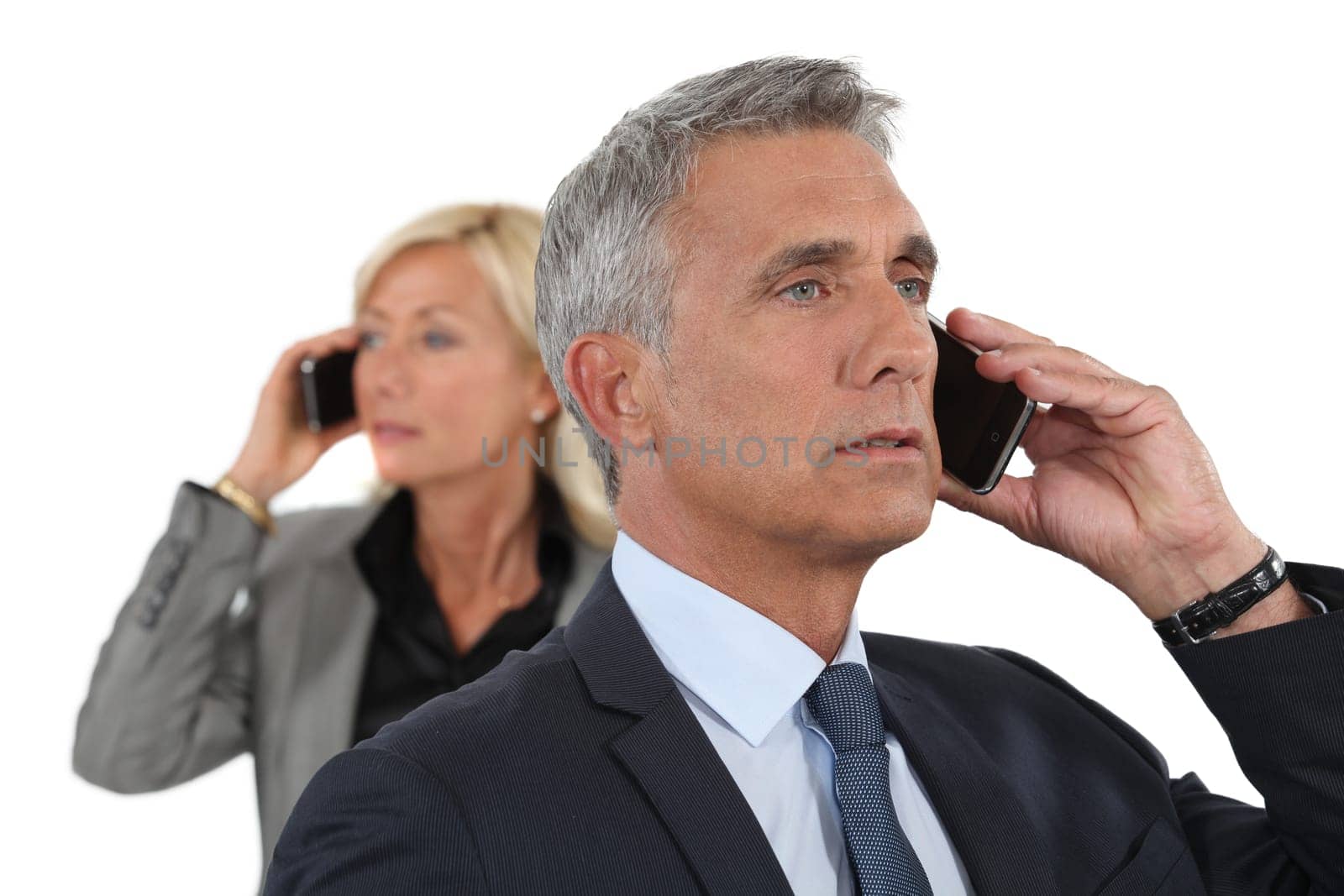 Mature business couple using cellphones