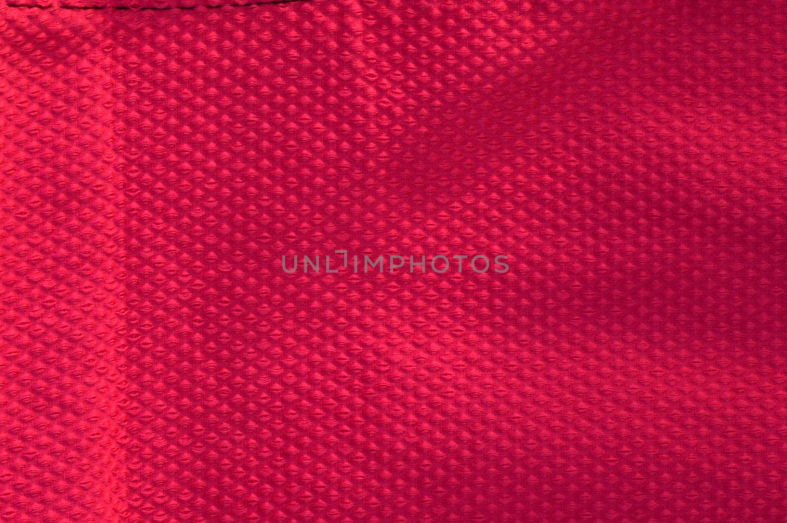 Vivid hot pink fabric background. Closeup of a textured pink fabric.