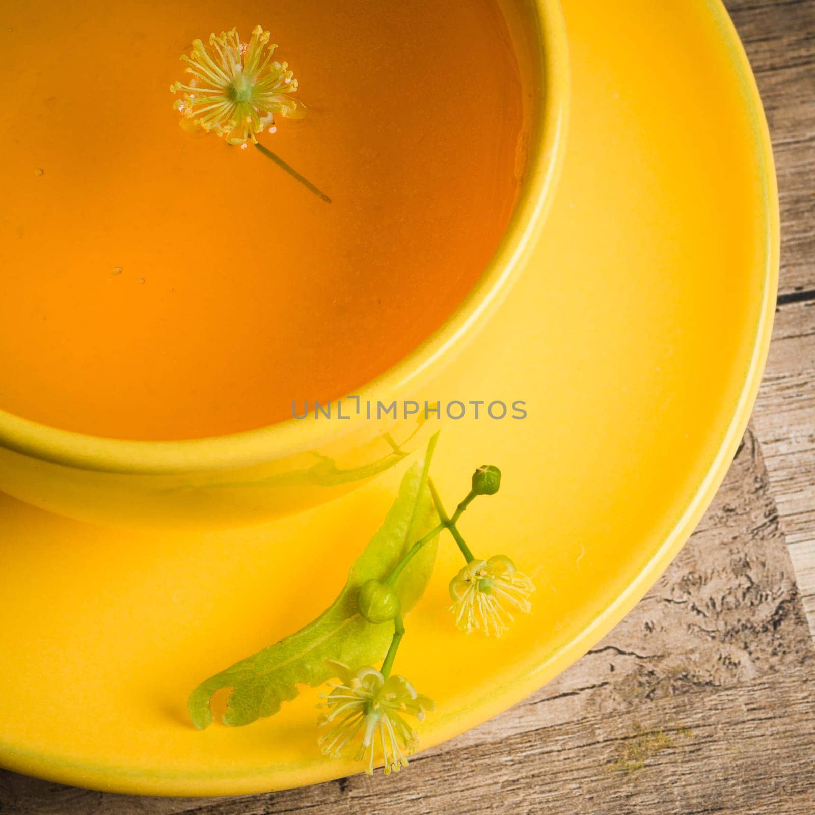 Yellow cup with linden tea on the table,  top view