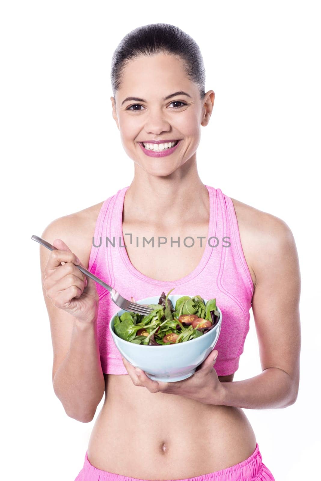 Slim young trainer eating salad