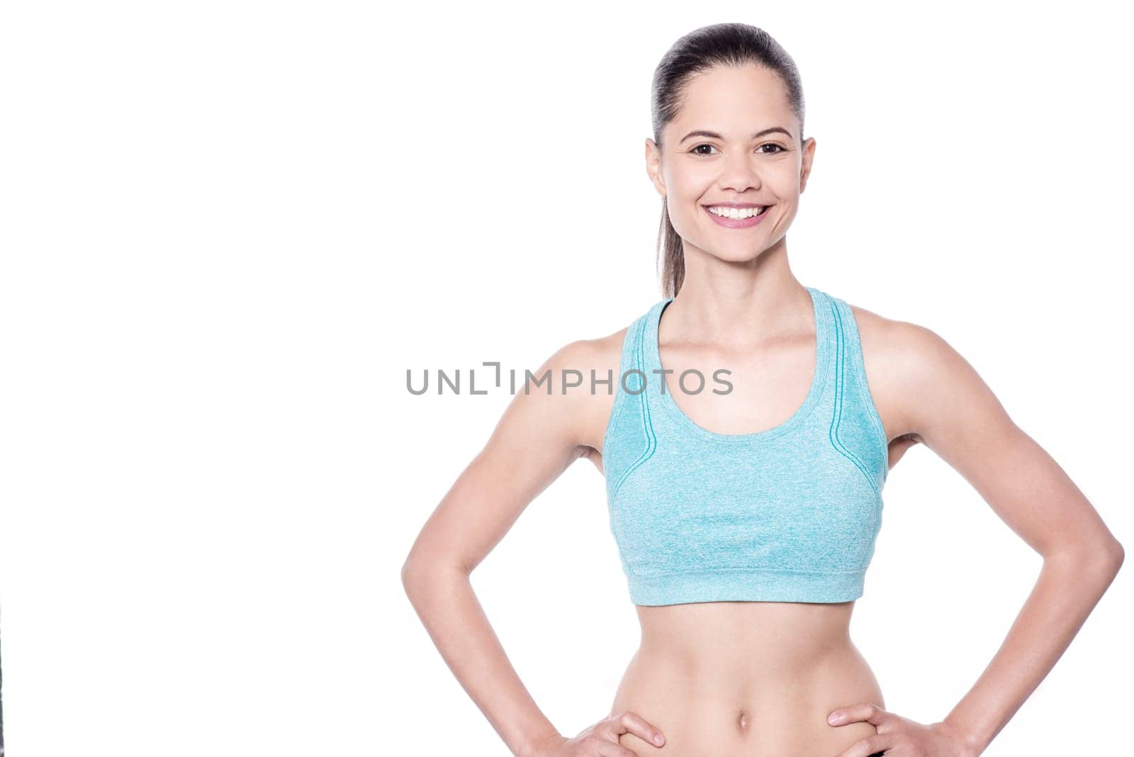 Fitness woman posing to camera with hands on waist