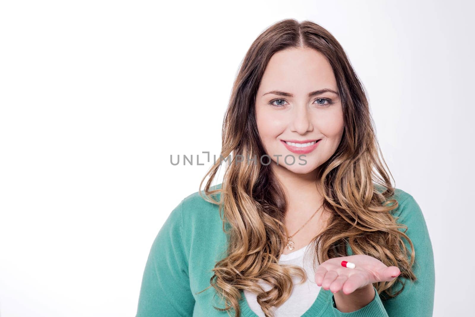 Young attractive woman showing vitamin pill