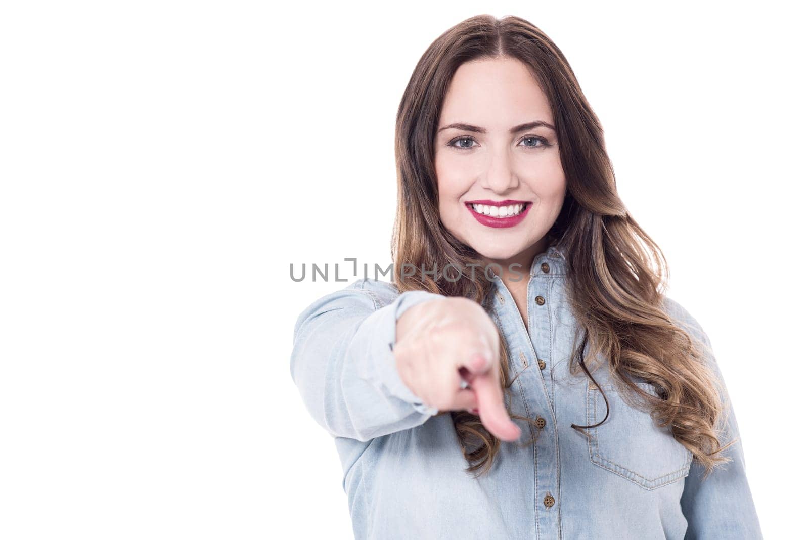 Smiling young woman pointing index finger at camera