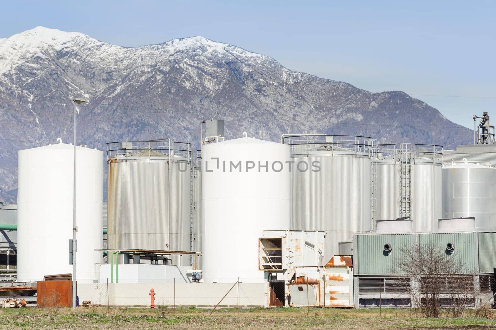 Tanks of a chemical plant at the foot of the mountains.