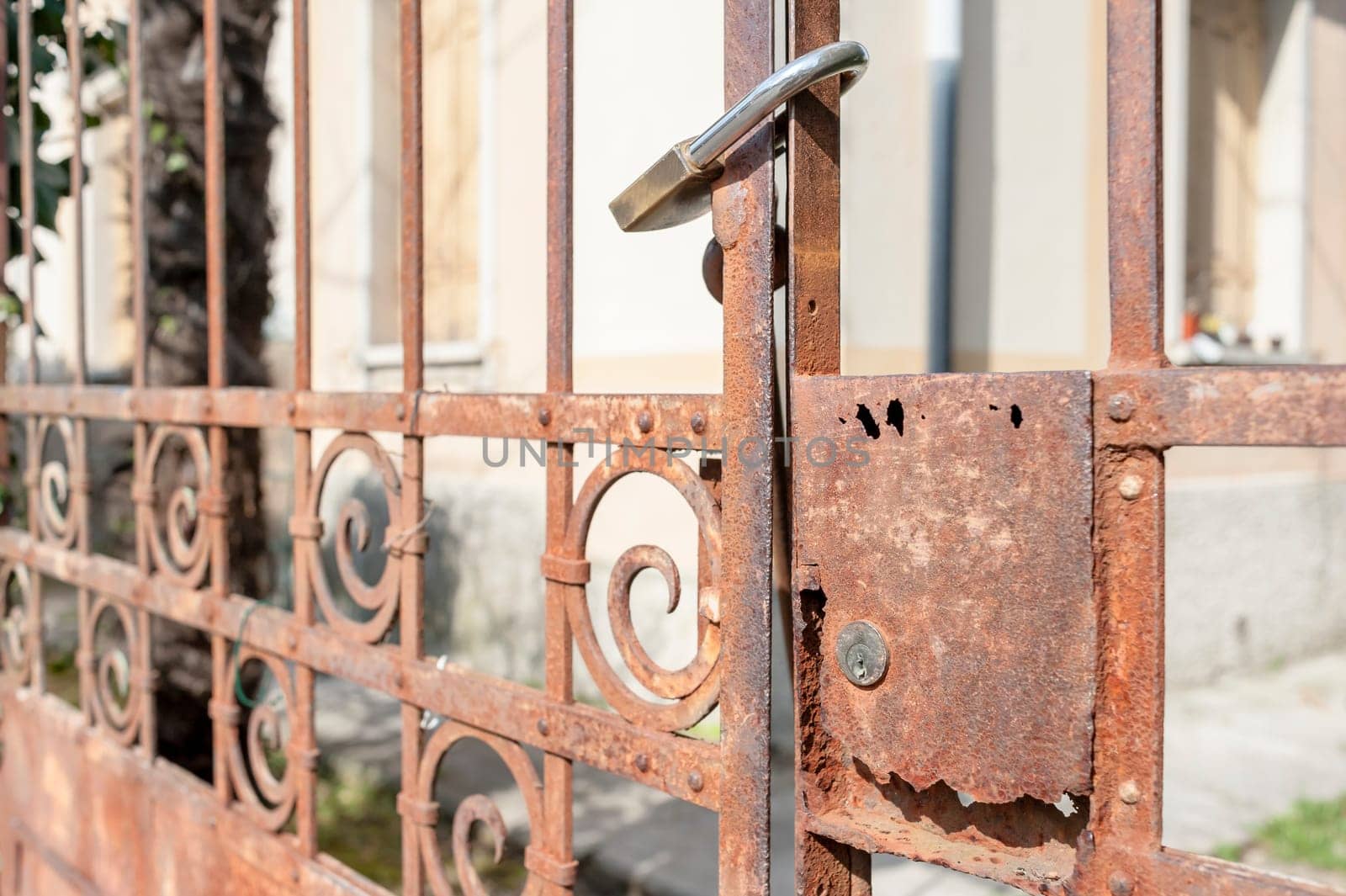 Rusty metal gate closed with padlock - concept image