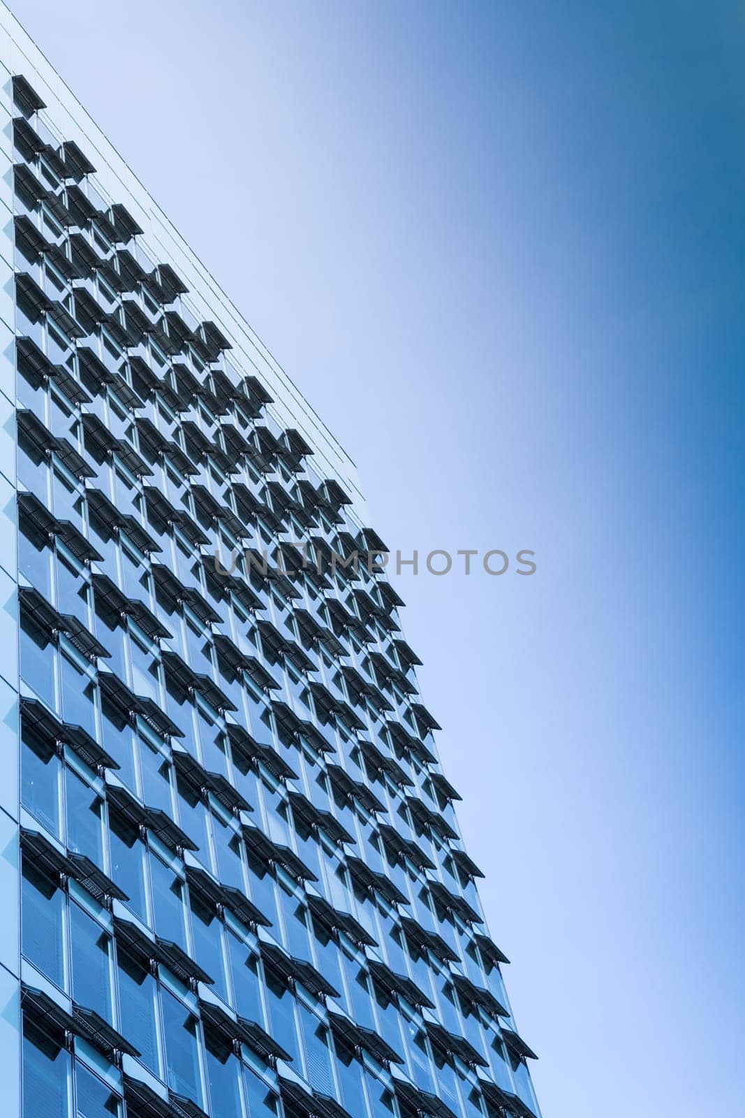 New modern high-rise steel and glass office building with large windows and open air conditioning ventilation system. Toned and filtered stock photo.