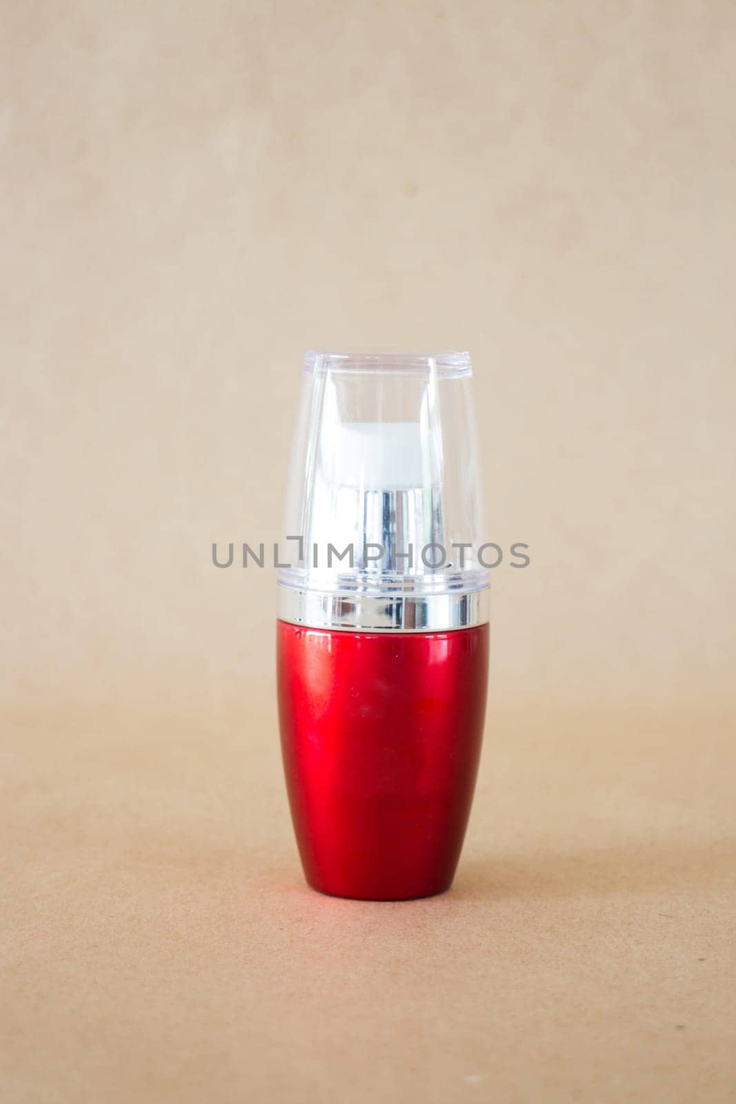 Shiny hard red bottle on brown background, stock photo