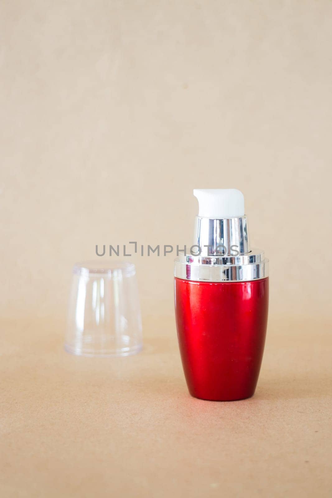 Shiny hard red bottle on brown background, stock photo