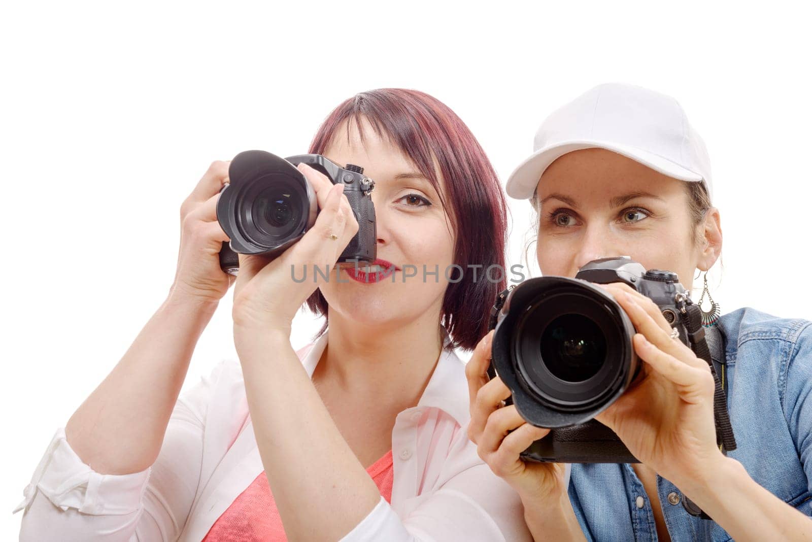 Two beautiful young women using a camera on hwhite background