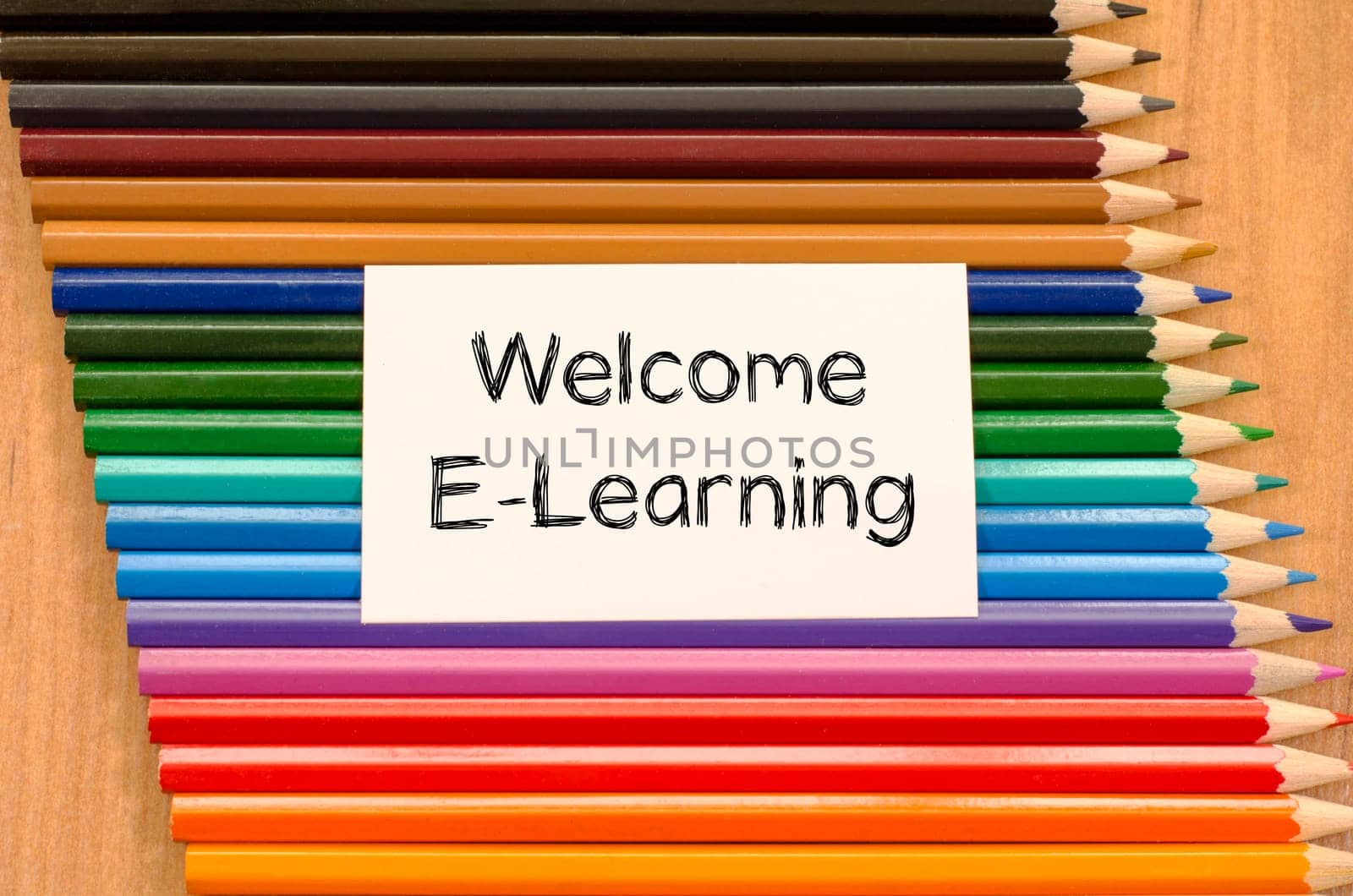 Welcome e-learning text concept and colored pencil on wooden background