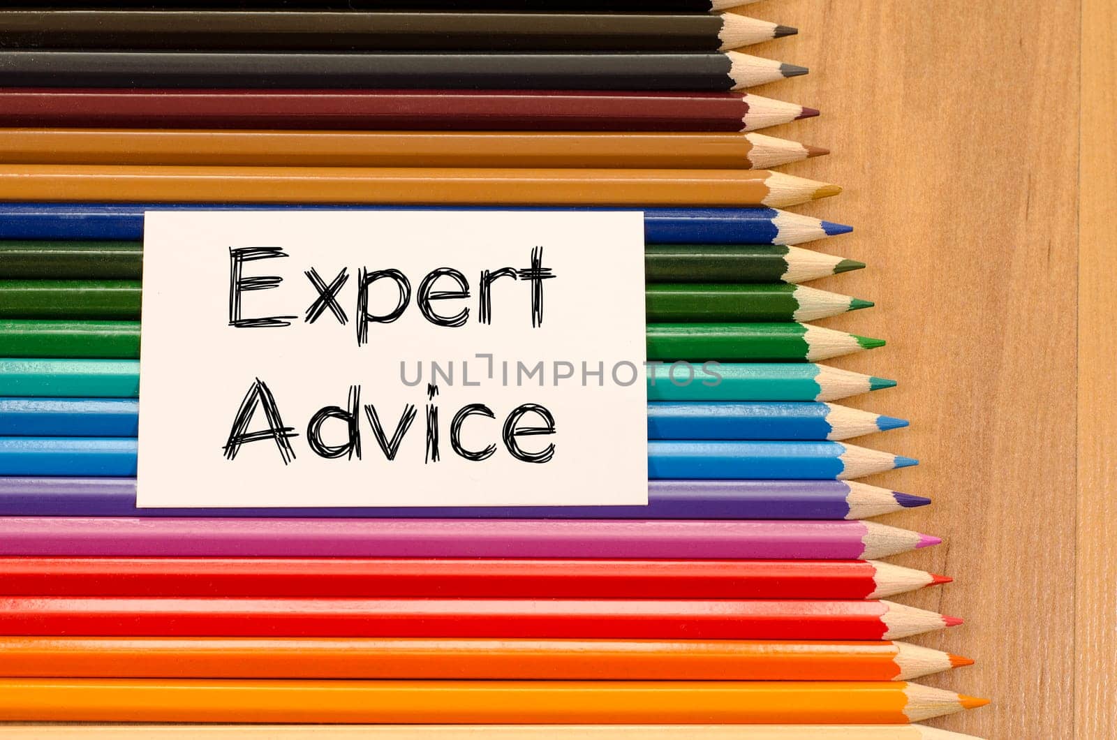 Expert advice text concept and colored pencil on wooden background
