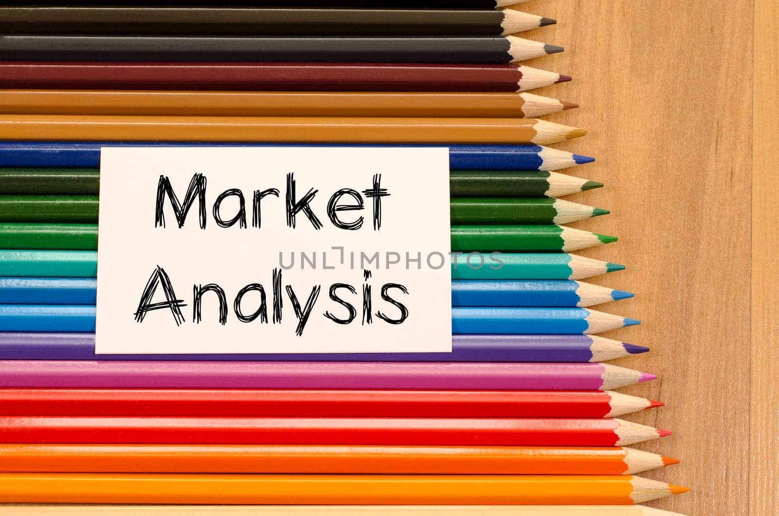 Market analysis text concept and colored pencil on wooden background