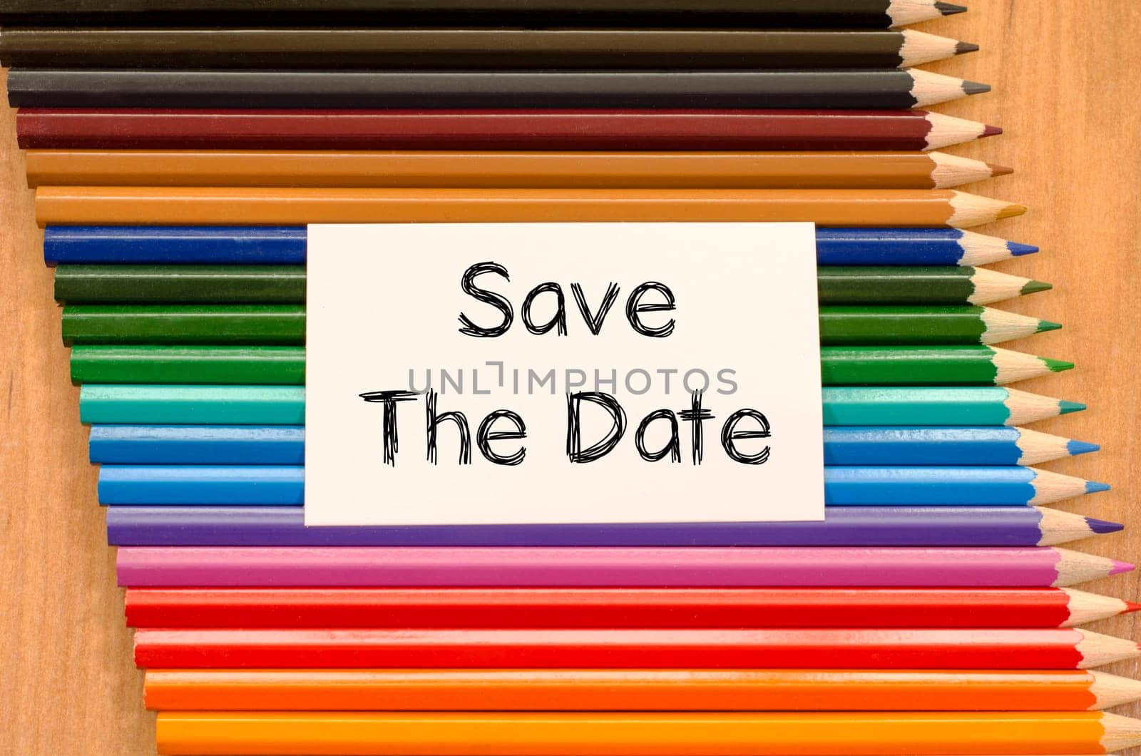Save the date text concept and colored pencil on wooden background
