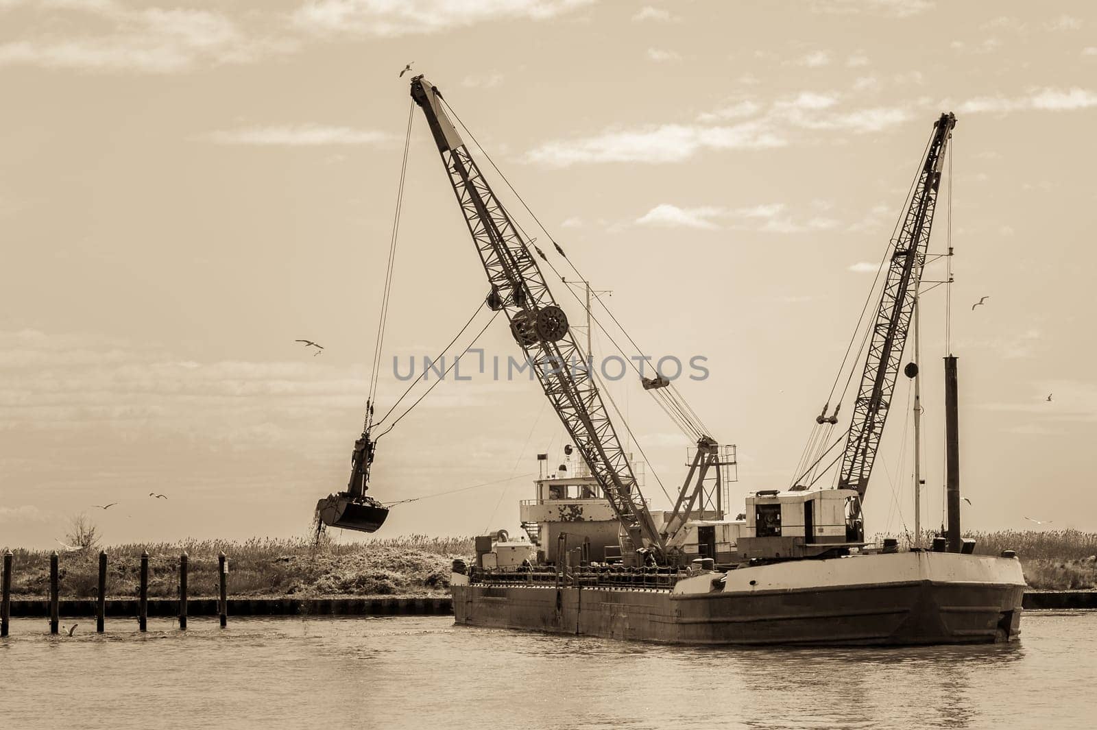 Vintage Effect. Small dredge marine,which is cleaning a navigation channel