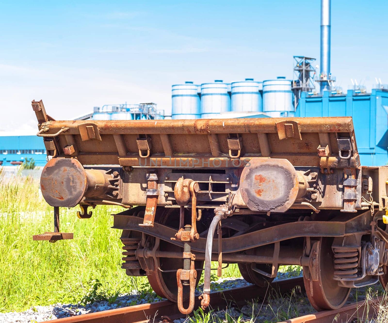Railway wagon freight,with a factory in the background
