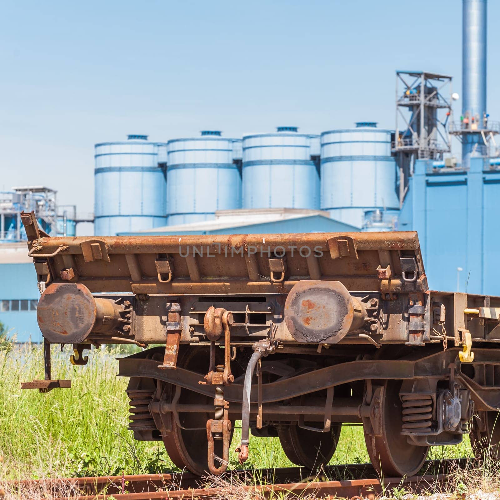 Railway wagon freight,with a factory in the background