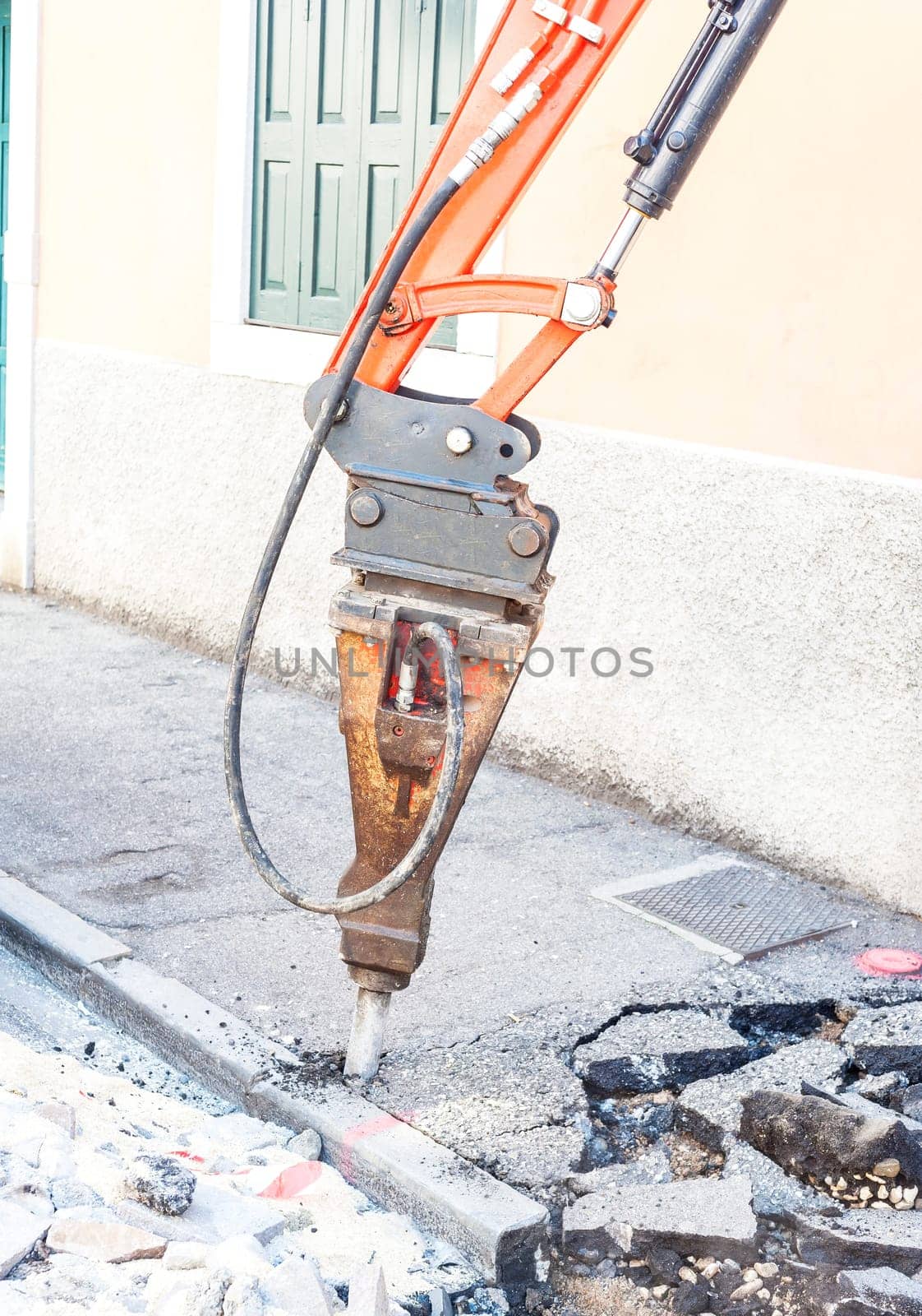 Large pneumatic hammer mounted on the hydraulic arm of a construction equipment