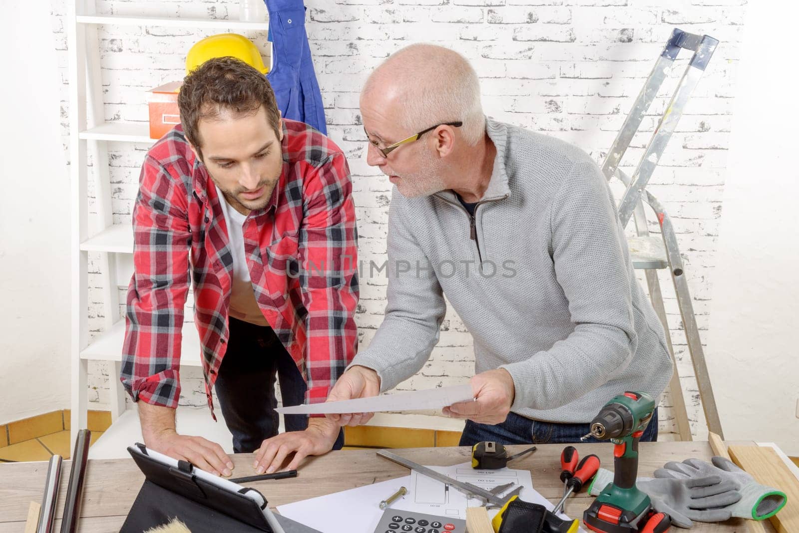 two technicians read a plan in the workshop