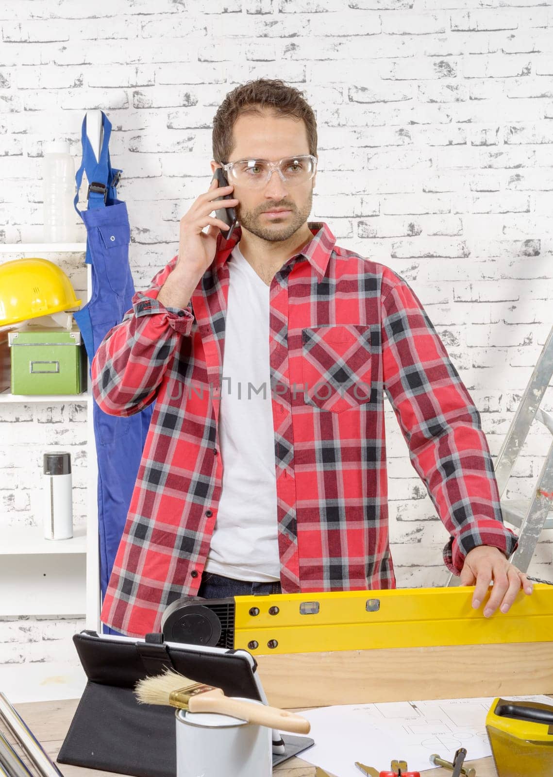 a  young worker phone, in his studio
