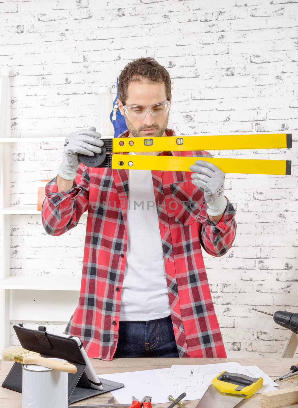 young man viewing a spirit level,  to read the position of the bubble to ensure a horizontal line