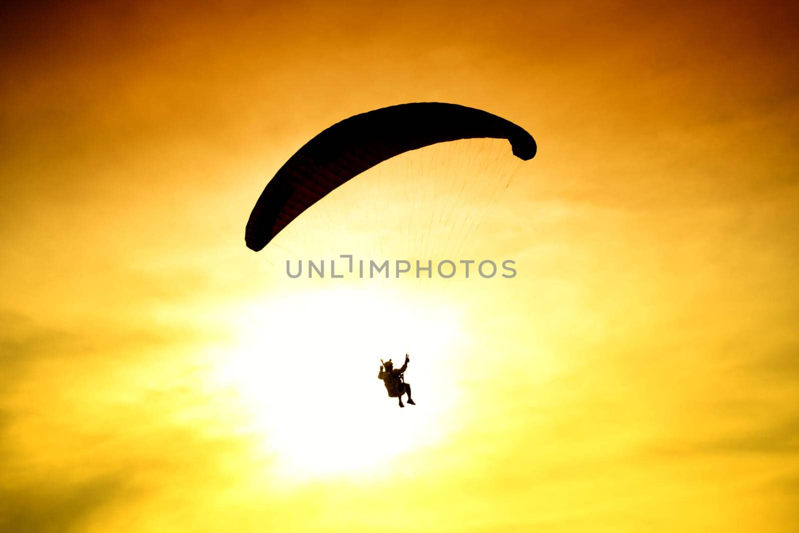 Silhouette of parachute on sunset background