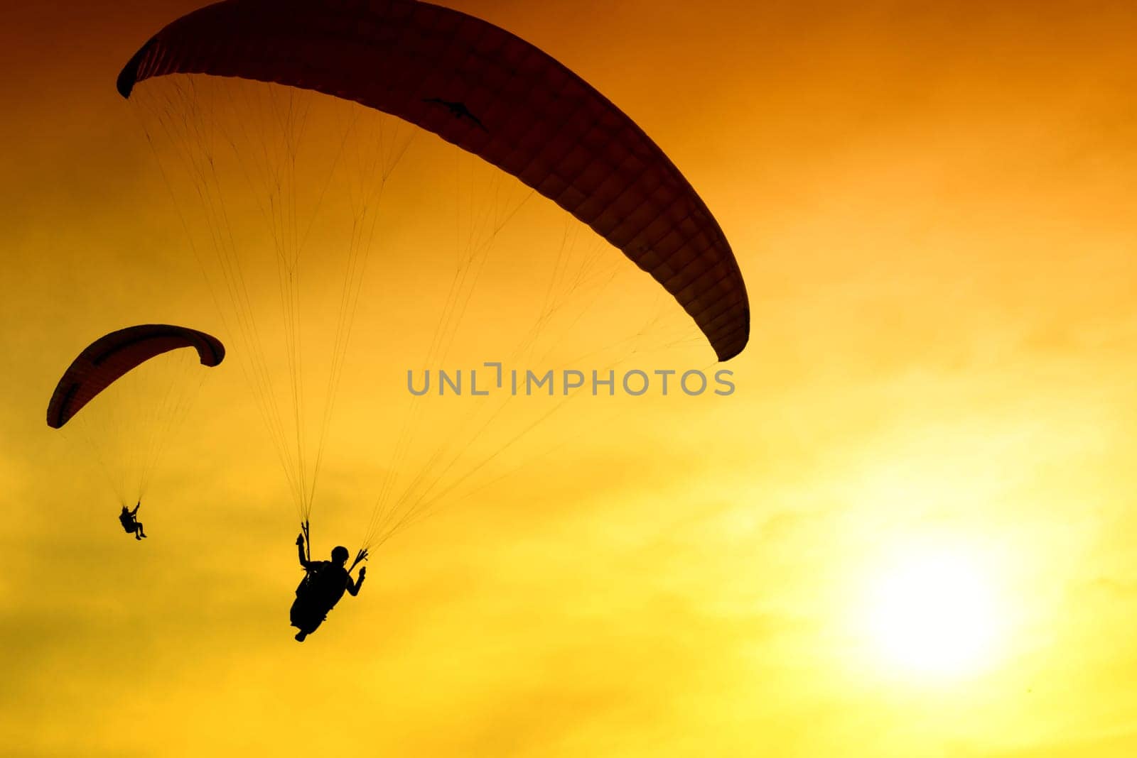 Silhouette of parachute on sunset background